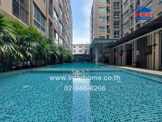 Outdoor swimming pool with adjacent apartment buildings and green plants