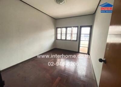 Bedroom with wooden flooring, window, and balcony access