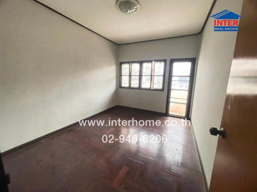 Bedroom with wooden flooring, window, and balcony access