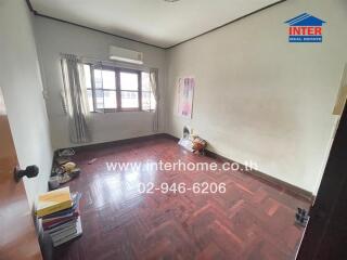 Empty bedroom with wooden floor and window