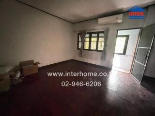 Spacious bedroom with dark hardwood floor and large windows