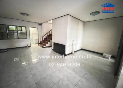Spacious living area with tiled flooring and a view of the staircase