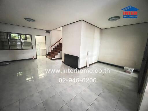 Spacious living area with tiled flooring and a view of the staircase