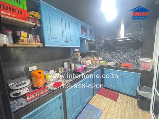 Modern kitchen with blue cabinetry and marble backsplash