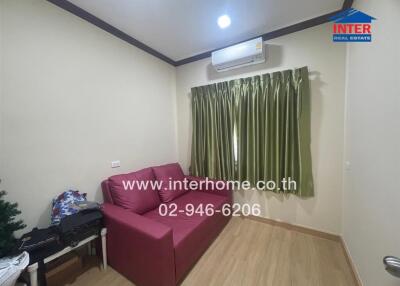 Small living room with red sofa and air conditioner