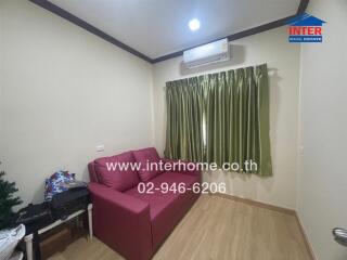 Small living room with red sofa and air conditioner