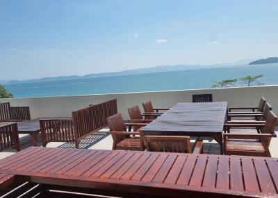 Outdoor patio with wooden furniture overlooking the sea