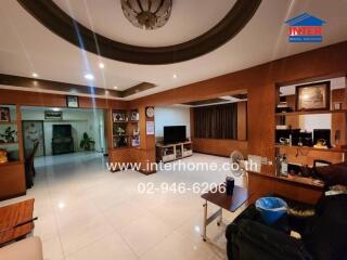 Spacious living room with built-in wooden shelving and modern lighting