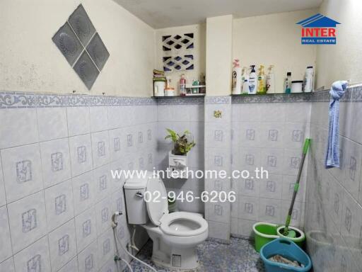 Bathroom with toilet and cleaning supplies