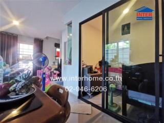 View of living area with glass sliding door, table and chairs, and miscellaneous items