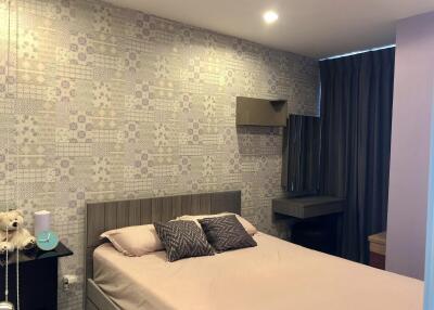 Modern bedroom with decorative wallpaper, bed, and side table