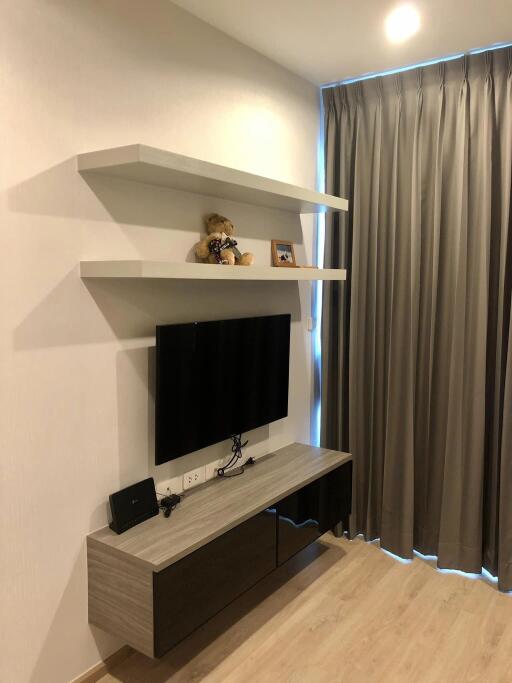 Modern living room with wall-mounted TV and floating shelves