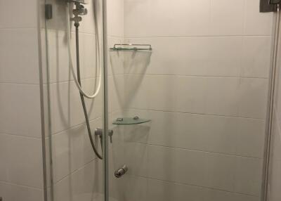 Modern bathroom shower with glass doors and white tiles