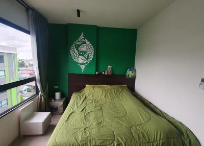 Cozy bedroom with green accent wall and large window