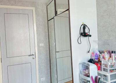 Modern bedroom with mirrored closet, dresser, and door