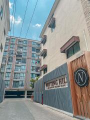Exterior view of Notting Hill condominium with entrance gate and signage