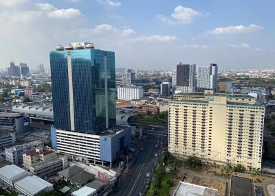 aerial view of city with tall buildings and residential areas under a blue sky with clouds