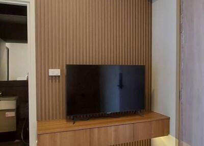 Living room with wall-mounted TV and wooden paneling