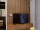 Living room with wall-mounted TV and wooden paneling