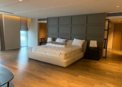 Spacious modern bedroom with a large bed and wooden flooring