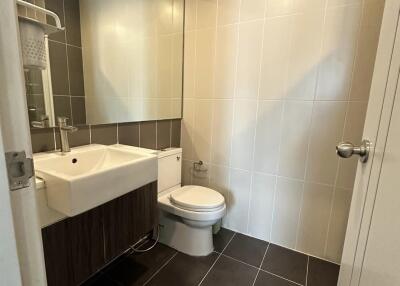 Modern bathroom with sink, toilet, and large mirror