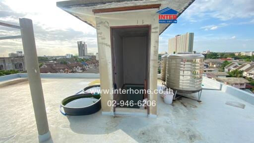 Rooftop area with water storage tanks and city view