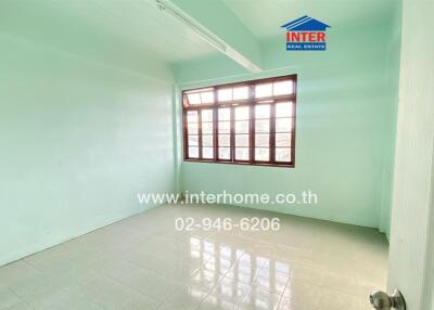 Empty bedroom with light green walls and large window