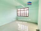 Empty bedroom with light green walls and large window