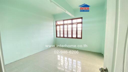 Empty bedroom with light green walls and large window