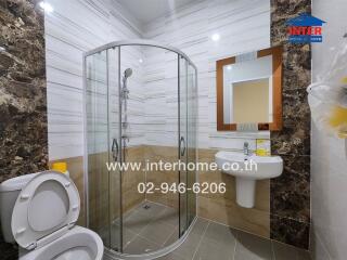 Modern bathroom with glass shower enclosure, sink, and toilet