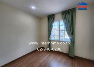 empty bedroom with wooden floor and green curtains