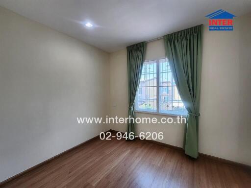 empty bedroom with wooden floor and green curtains