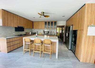 Modern kitchen with island, wooden cabinetry, and bar stools