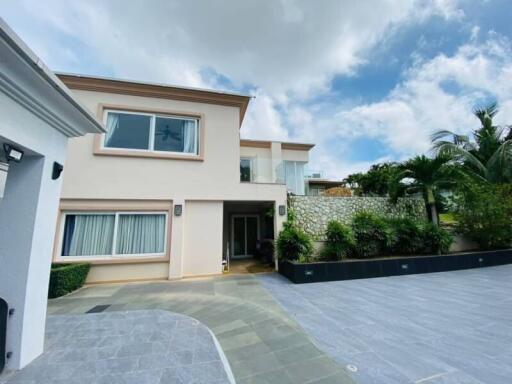 Modern two-story house with large driveway and lush landscaping