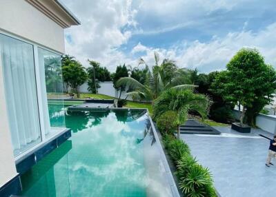 Luxury outdoor area with infinity pool and lush garden