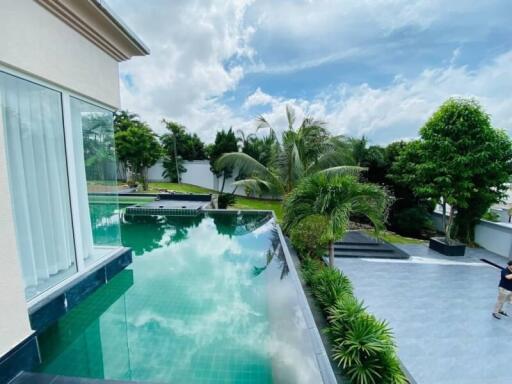 Luxury outdoor area with infinity pool and lush garden