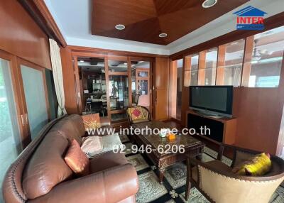 spacious living room with brown leather sofa and TV