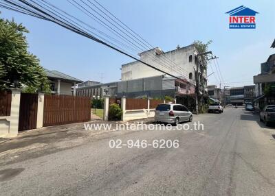 Street view of neighborhood with residential buildings and parked vehicles