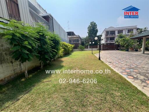 Garden with greenery, lawn, and surrounding buildings