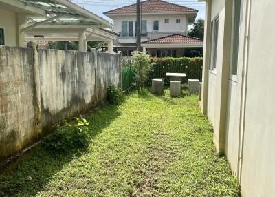 Photo of a backyard with a grassy area and adjacent buildings