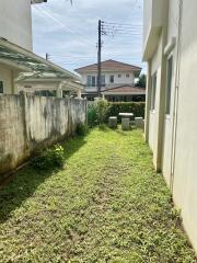 Photo of a backyard with a grassy area and adjacent buildings