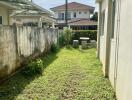 Photo of a backyard with a grassy area and adjacent buildings