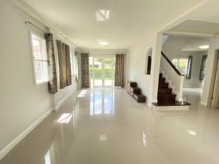 Spacious living room with large windows and stairs