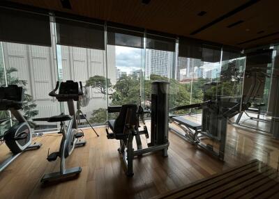 Modern gym with exercise equipment and large windows with city views