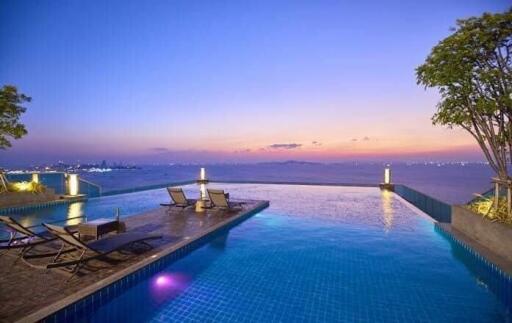 Infinity pool area with lounge chairs and stunning sunset view