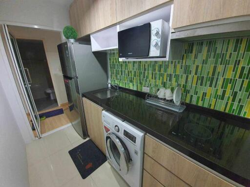 Modern kitchen with wooden cabinets, green tiled backsplash, and appliances