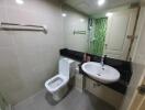 Modern bathroom with green accent tiles and white fixtures