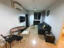 Modern living room with black leather sofa, wall-mounted TV, and dining table