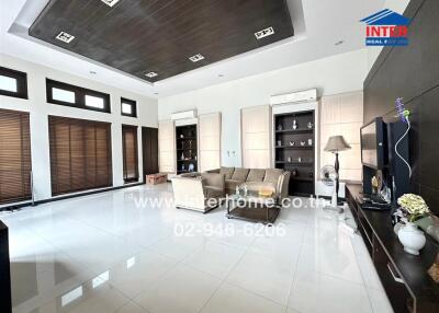 Spacious and modern living room with large windows and elegant furniture.