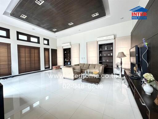 Spacious and modern living room with large windows and elegant furniture.